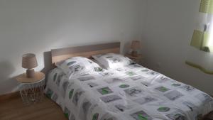 a bedroom with a bed with a comforter and two lamps at Maison entière moderne tout confort de 92m² in Angoulême