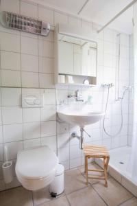 łazienka z toaletą, umywalką i wanną w obiekcie Ferienwohnung Chalet Zwirbeli w mieście Adelboden