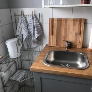 a kitchen counter with a sink and a shelf at Ferienwohnung Von Paris in Petersberg