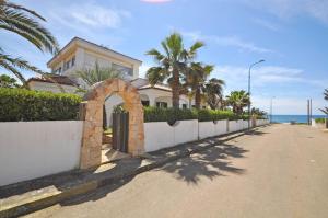 a house on the side of a street with palm trees at Villa Sunset in Torre Suda