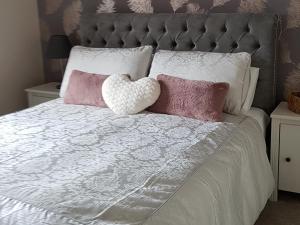 ein Bett mit rosa und weißen Kissen darauf in der Unterkunft Gullane View Apartment in Gullane