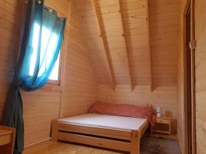 a small room with a bed in a cabin at Domki Letniskowe Martynka in Niechorze