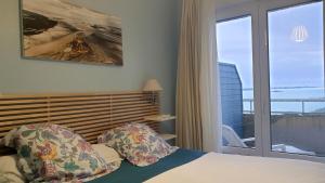 a bedroom with a bed and a window with a view at La Conchee in Saint Malo