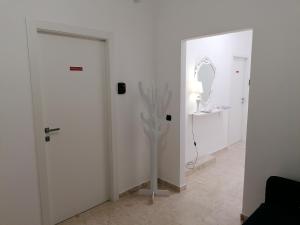 a white room with a white door and a mirror at Tanzi Home in Bari