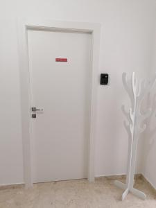 a white door in a white room with a tree sculpture at Tanzi Home in Bari