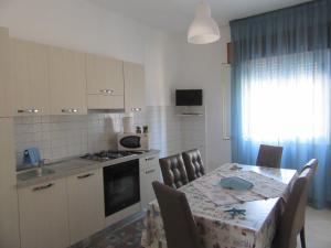 a kitchen with a table with chairs and a table and a table and a kitchen at Casa Vacanza Tra Cielo e Mare in Custonaci