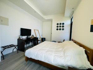 a bedroom with a white bed and a desk at Chao Zhou 86 B&B in Chaozhou