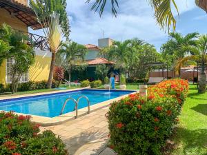 una piscina frente a una casa con palmeras en La Dolce Vita Flat & Pousada, en Praia do Frances
