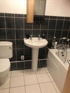 y baño con lavabo, aseo y bañera. en Newcastle Seafront Apartment with Wifi and Parking en Newcastle