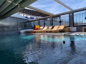 a swimming pool with benches and water in a building at Complex Koko Hills in Sapareva Banya