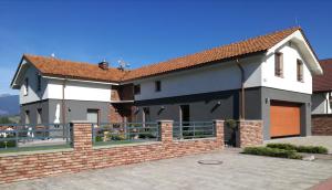ein Haus mit einem Steinzaun davor in der Unterkunft Pension Lunatyk in Liptovský Mikuláš