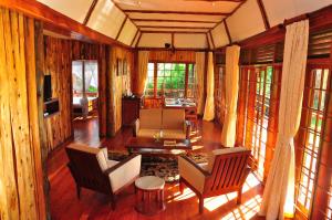 a living room with chairs and a television and windows at Muthu Lake Naivasha Country Club, Naivasha in Naivasha