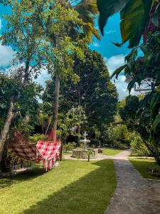 a park with a bench with a red blanket on it at Chez Max Pousada in Morro de São Paulo