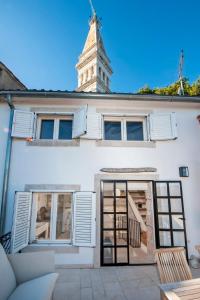 a white building with a clock tower in the background at Monte Sea View Residence in Rovinj