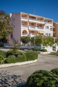 a large apartment building with bushes in front of it at Villa Rossa 2 in Tučepi