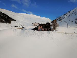 una casa en la nieve en una montaña nevada en Al Dos en Livigno
