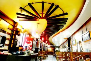 a restaurant with a large chandelier hanging from the ceiling at Hotel Prayag in Allahābād