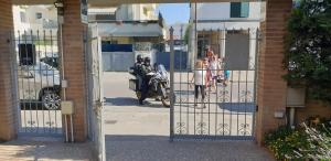 un grupo de personas caminando a través de una puerta con una motocicleta en B&B ENSILEVA BEACH, en Porto Garibaldi