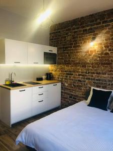 a bedroom with a white bed and a brick wall at Property Apart - Ruska Centrum in Wrocław