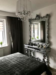 1 dormitorio con espejo y 1 cama en Apartament na Skrzypka en Cieszyn