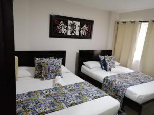 um quarto com duas camas e um sofá em Caribbean Island Hotel Piso 2 em San Andrés