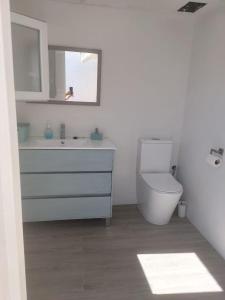 オリーバにあるCasa en Primera Línea de Playaの洗面台とトイレを備えた白いバスルーム