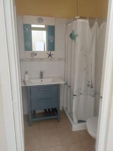 a bathroom with a sink and a shower curtain at Casa en Primera Línea de Playa in Oliva