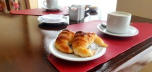 dos croissants en un plato en una mesa con una taza de café en Hotel Vitalia en Ushuaia