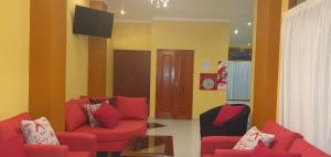 sala de estar con 2 sofás rojos y TV en Hotel Vitalia en Ushuaia