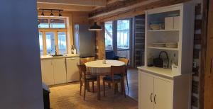 a kitchen with a table and chairs in a room at Utopia Dom przy winnicy in Nowica