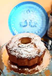 a powdered donut on a plate with a blue plate at Agriturismo Pira Pinta in Dorgali