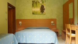 ポルト・ガリバルディにあるB&B ENSILEVA BEACHのベッドルーム1室(ベッド1台、テーブル、絵画付)