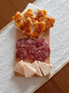 una tabla de cortar con queso y carne sobre una mesa en Agriturismo Pira Pinta, en Dorgali