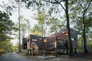 una casa de madera en el bosque con una carretera en Aldea Os Muiños, en As Mirans