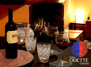 eine Flasche Wein und zwei Gläser auf dem Tisch in der Unterkunft Casa Odette Calcata in Calcata