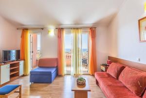 a living room with a red couch and a tv at Villa Rossa 2 in Tučepi