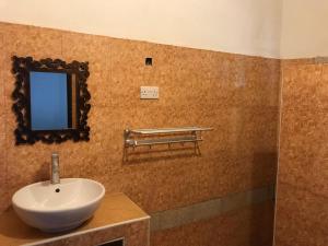 a bathroom with a sink and a mirror on the wall at Bahati Hotel Villas in Bwejuu