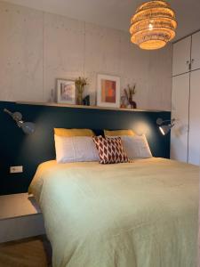 1 dormitorio con 1 cama grande y cabecero azul en WAD NOU Terschelling heerlijk duurzaam chalet!, en Midsland