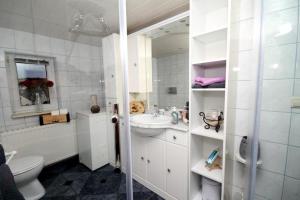 a white bathroom with a sink and a toilet at Ferienwohnung Sonnenaufgang in Penig +19 photos
