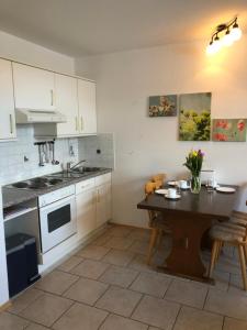 a kitchen with white cabinets and a wooden table at Gutshaus Bliesekow in Bliesekow