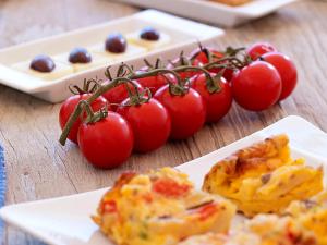 a bunch of tomatoes and a plate of food on a table at Artemis Seaside Resort in Paliochori