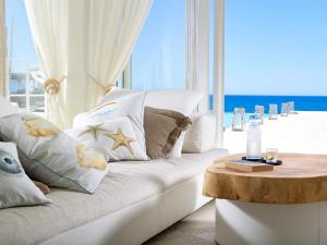 a living room with a white couch and a table at Artemis Seaside Resort in Paliochori