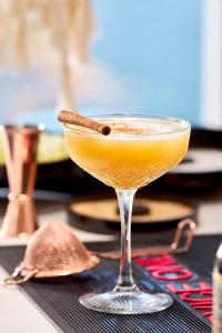 a drink in a martini glass with a cigar in it at Artemis Seaside Resort in Paliochori