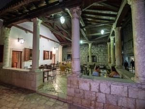 two people sitting at tables in an old building at B&B Rooms Old Town Rab in Rab
