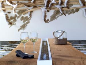 two glasses of white wine on a wooden table at Artemis Seaside Resort in Paliochori