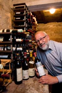 a man standing next to a bunch of wine bottles at Fossheim Hotel Lom in Lom