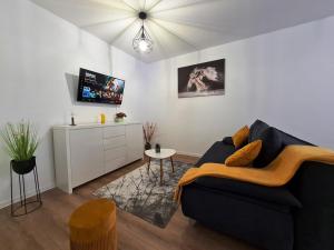 ein Wohnzimmer mit einem schwarzen Sofa und einem TV in der Unterkunft Apartament Luca P4B Oradea Prima Residence in Oradea