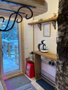 a kitchen in a tiny house with a window at Tiigrisilma Treehouse in Kohila
