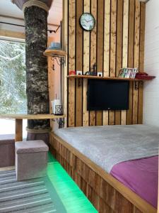 a bedroom with a bed and a clock on the wall at Tiigrisilma Treehouse in Kohila