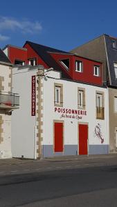 ein weißes Gebäude mit einem Schild an der Seite in der Unterkunft Au bout du Port in Le Guilvinec